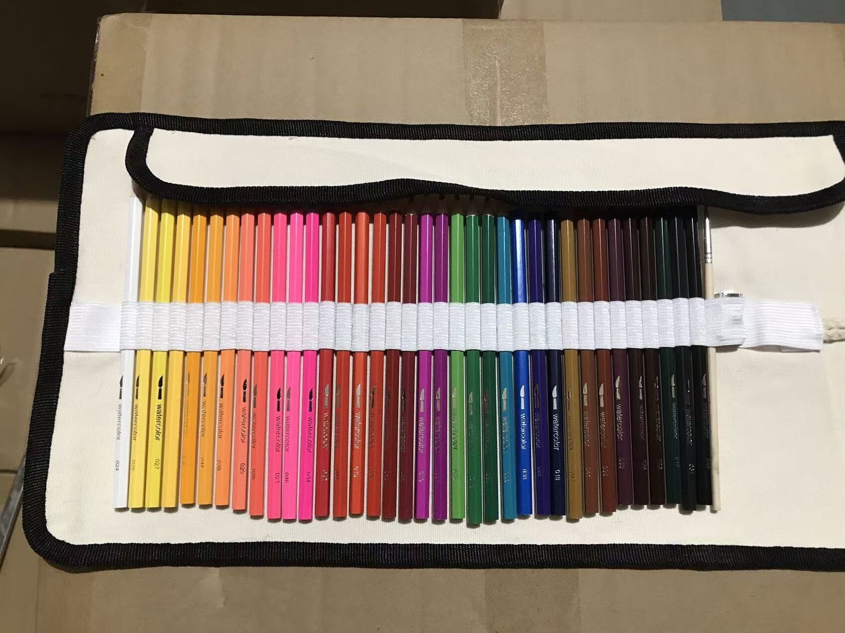Watercolor pencils arranged inside the open canvas wrap