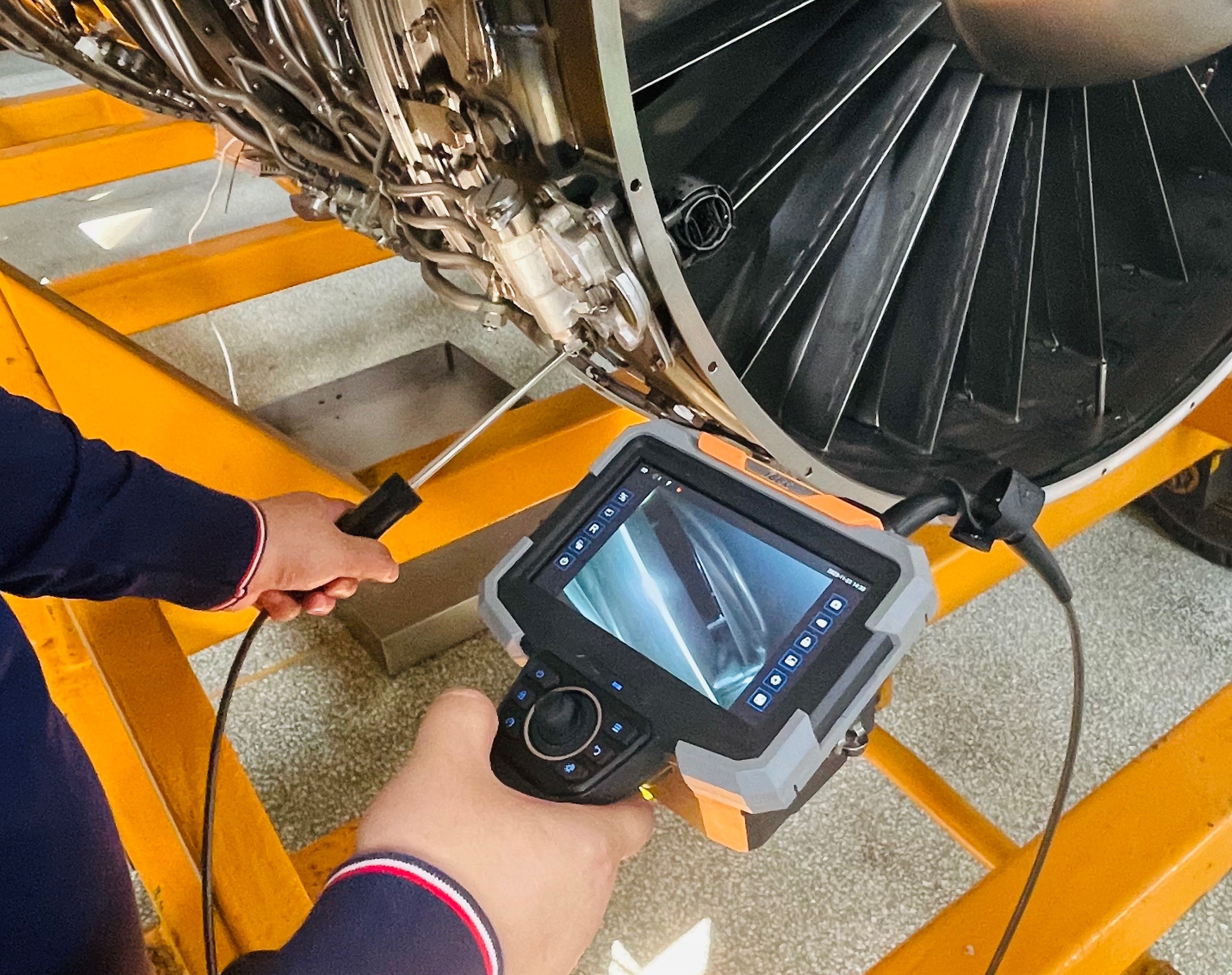 Engineer using a borescope camera to inspect a turbine blade