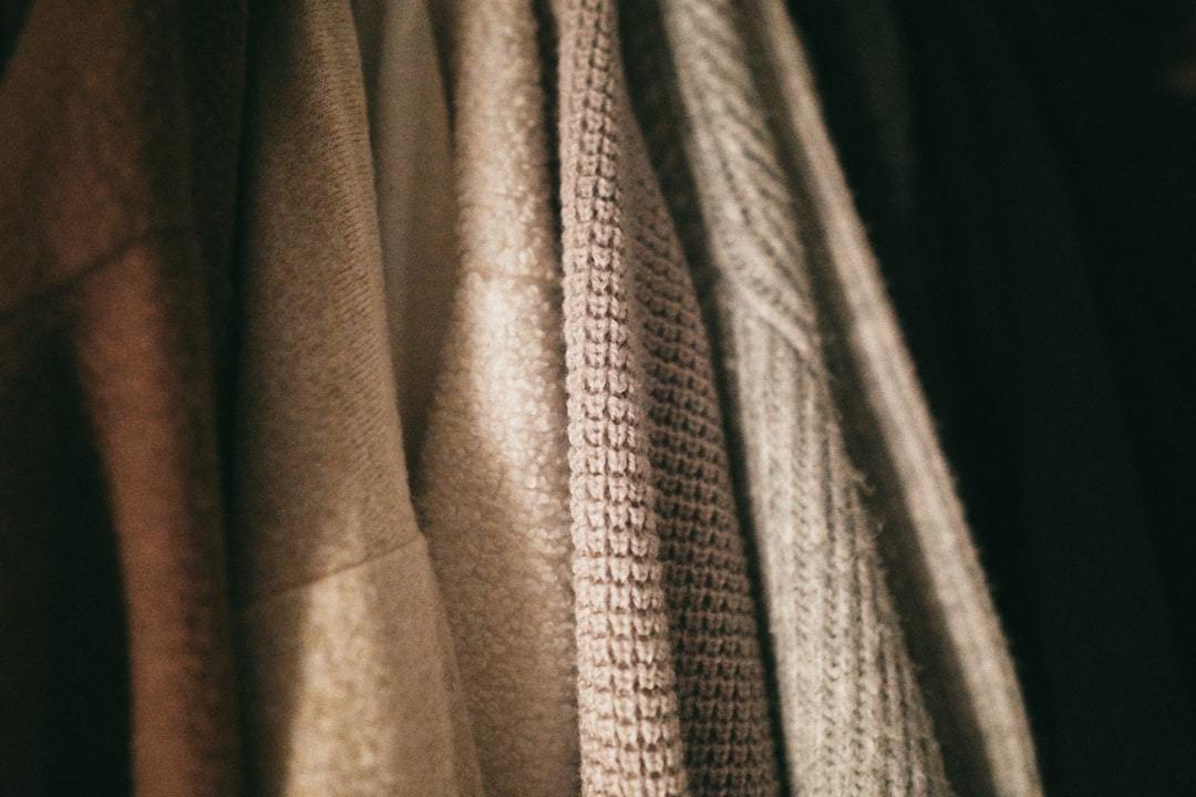Stack of soft knitted cashmere blankets folded on a table in a textile workshop
