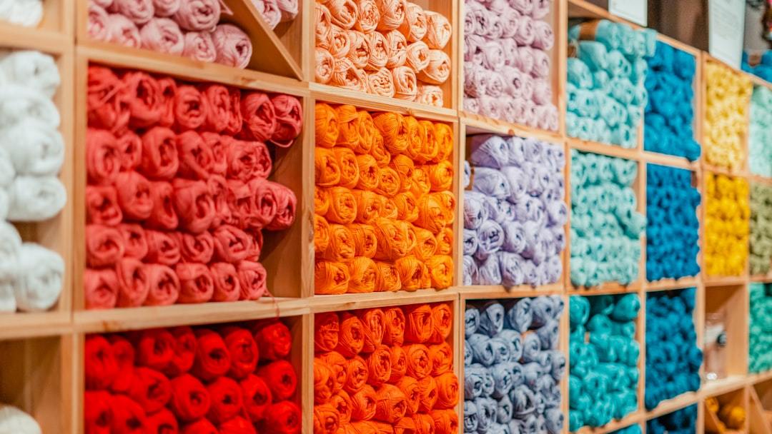Rows of naturally dyed cashmere yarn cones in a spinning workshop