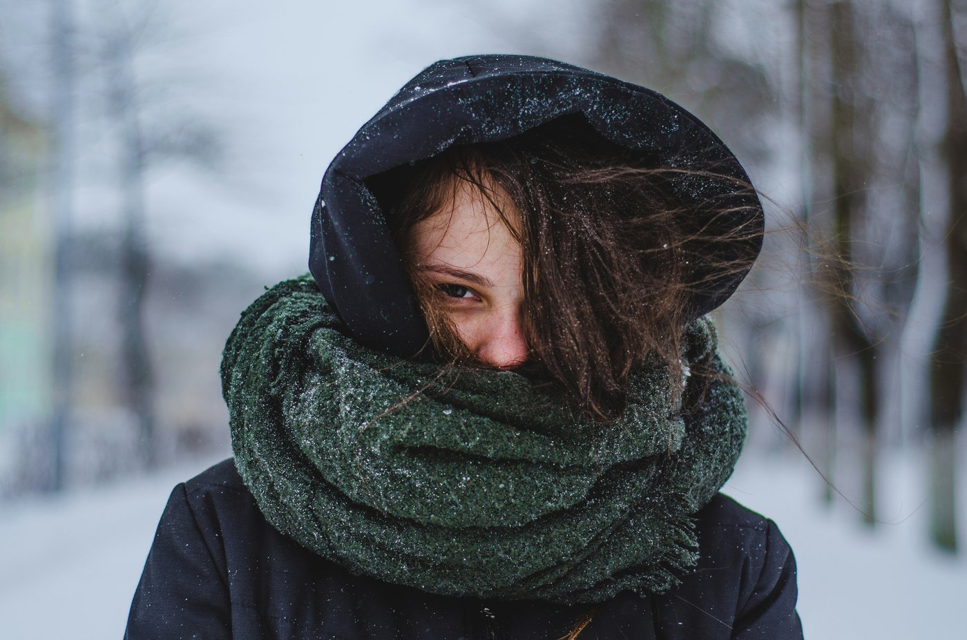 Woman wearing a hoodie layered under a vivid green cashmere scarf, illustrating the elevated loungewear and casual-luxury styling that drives 2026 B2B demand