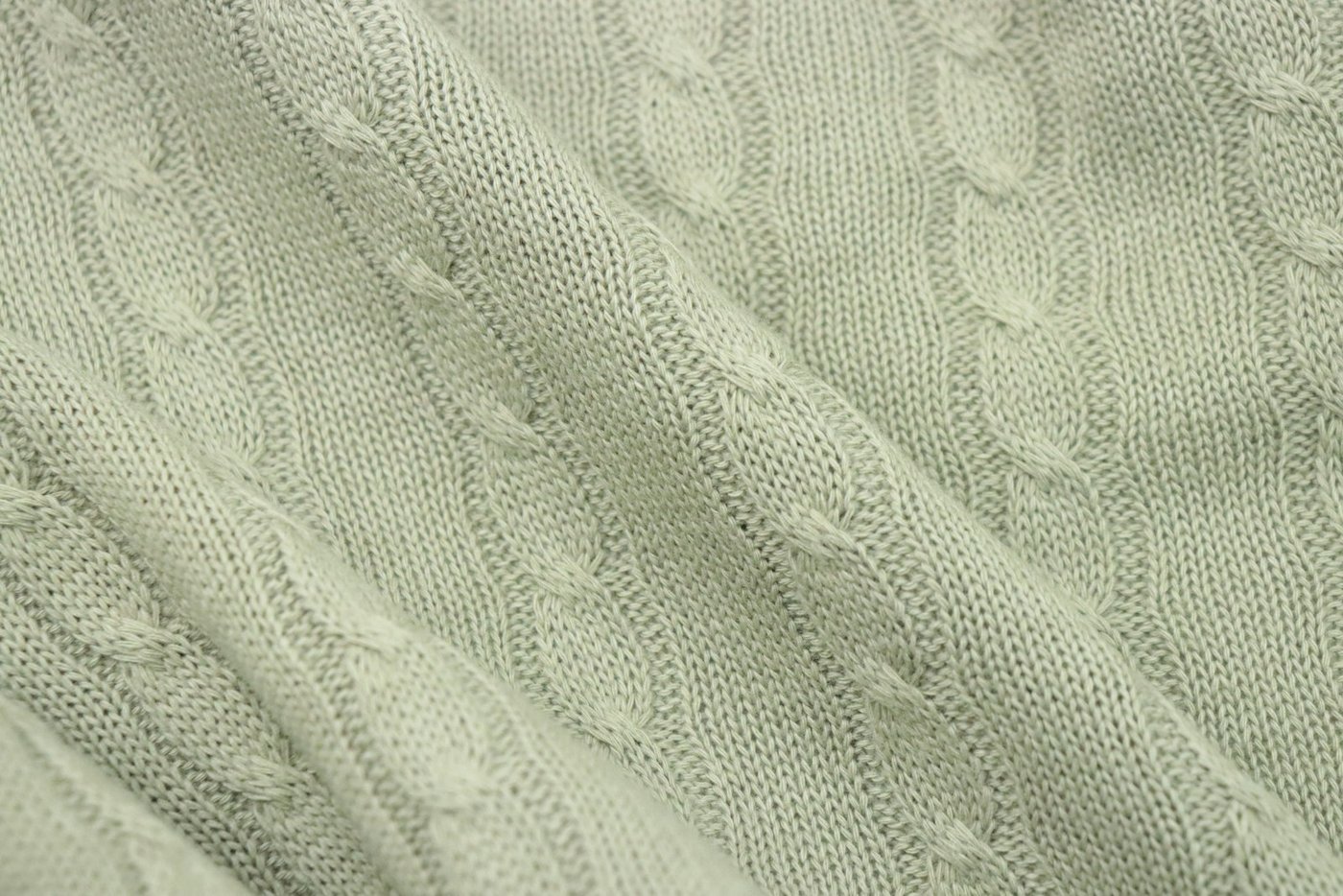 Close-up of a soft cashmere knit texture, showing the stitch definition and density that determine how a sweater drapes and wears