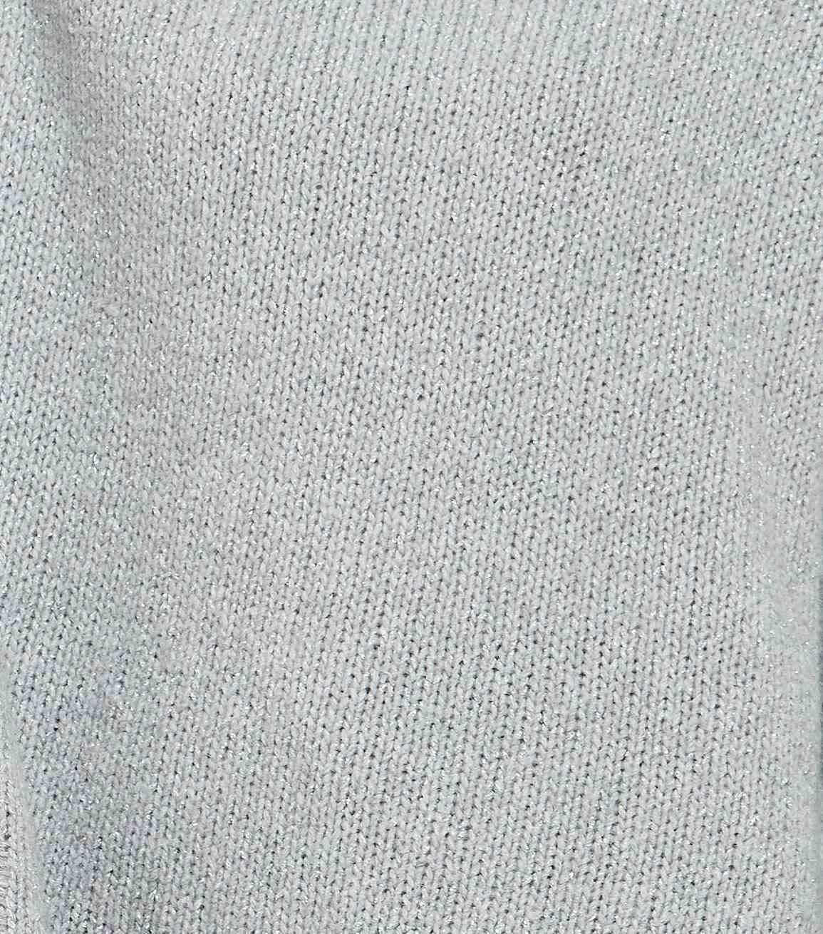 Macro photograph of a fine-gauge cashmere knit showing stitch columns across the fabric surface, the evenness that yarn specifications are written to control
