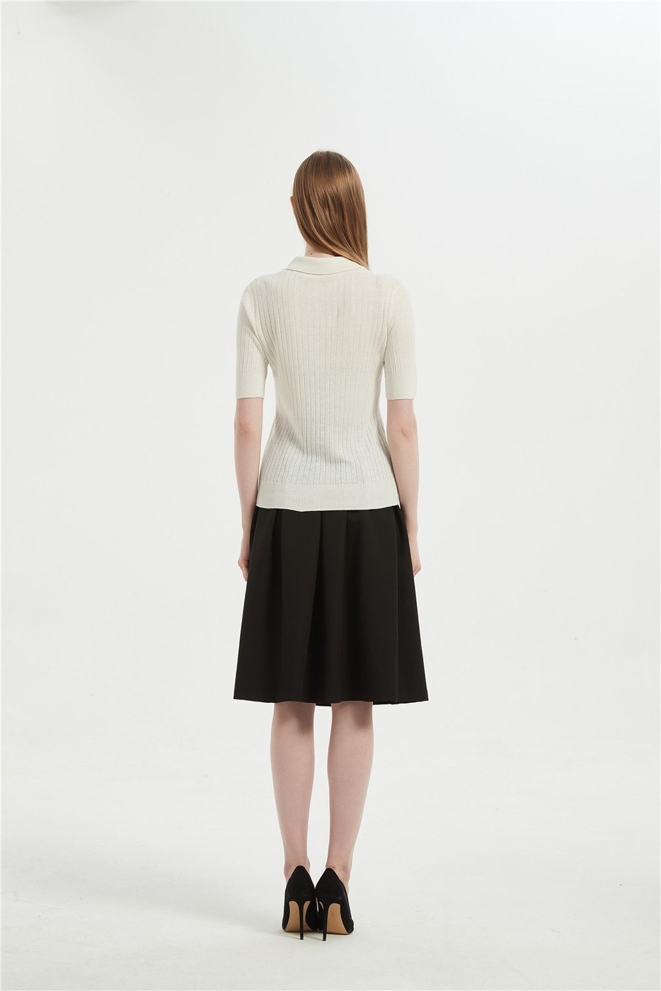 Back view of an ivory short-sleeve cashmere knit top worn with a black skirt