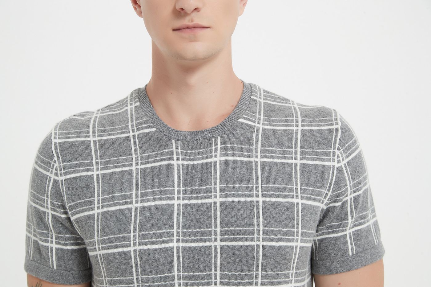 Close-up of the neckline and shoulder seam on a grey checked short-sleeve cashmere knit