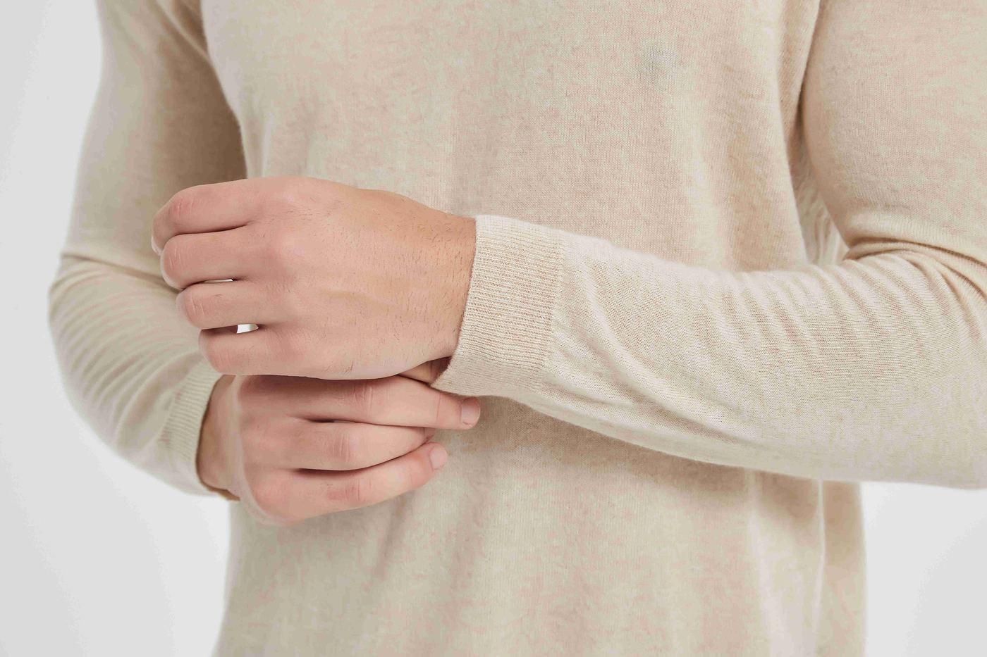 Back view of an oatmeal cashmere crew-neck sweater showing the shoulder and side seams