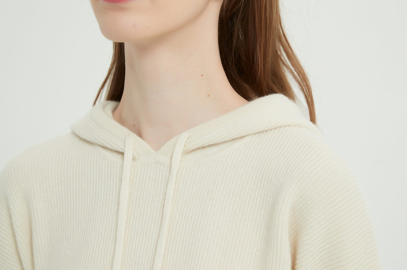 Close view of an undyed cream cashmere hoodie showing the drawcord and knit detail