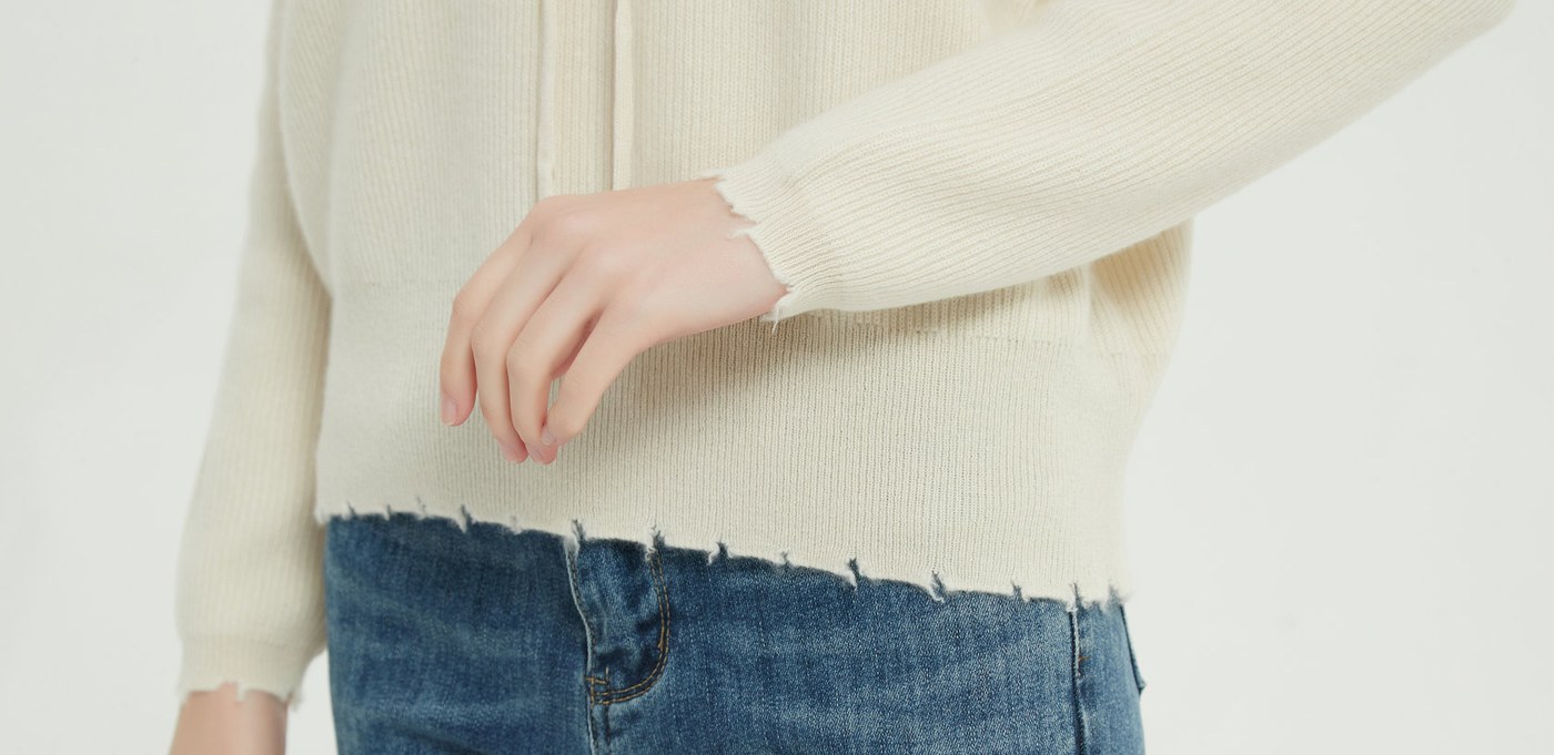Detail view of the hem and rib of an undyed cashmere sweater