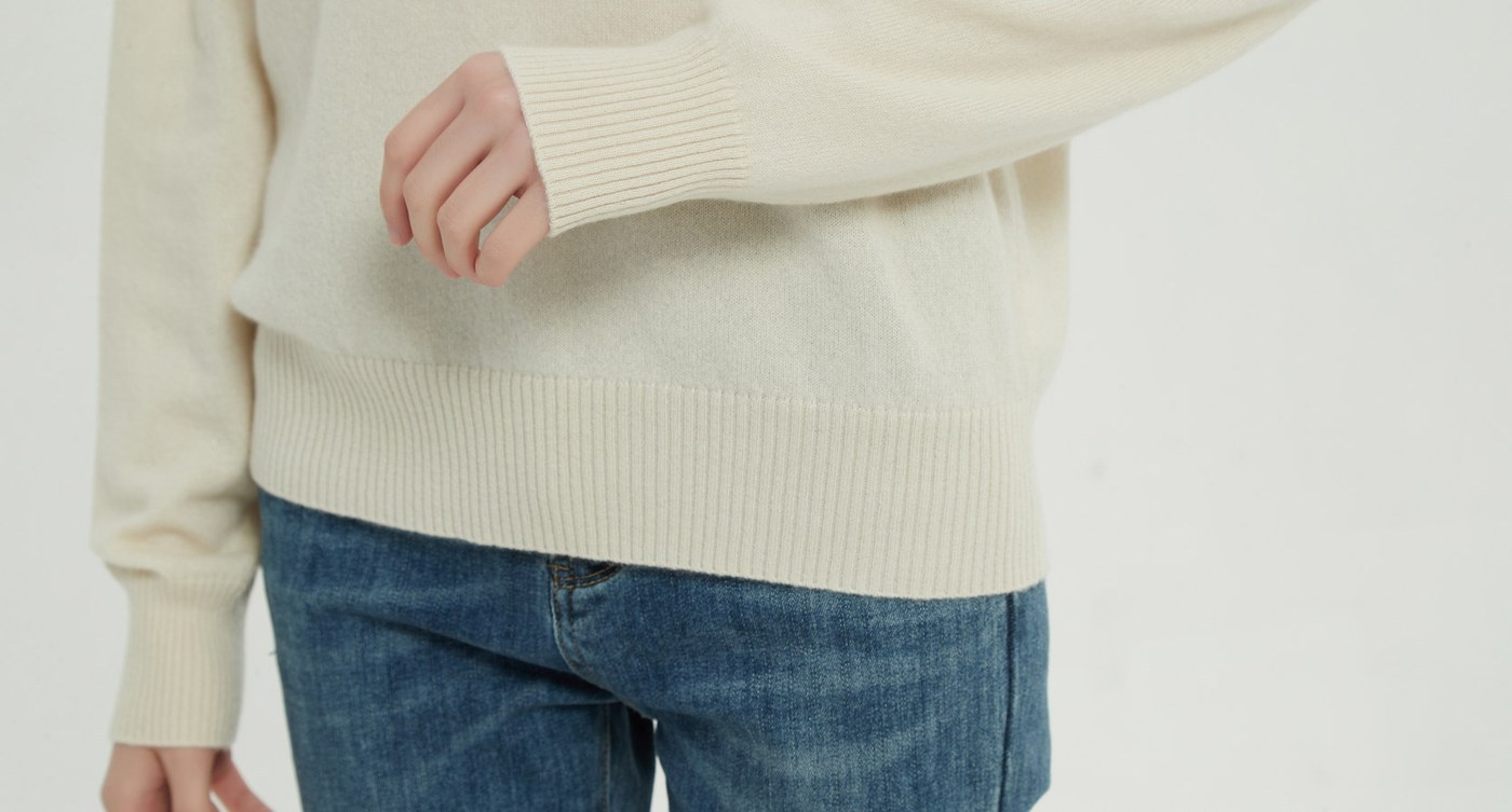 Close view of a recycled-style melange knit surface at the hem