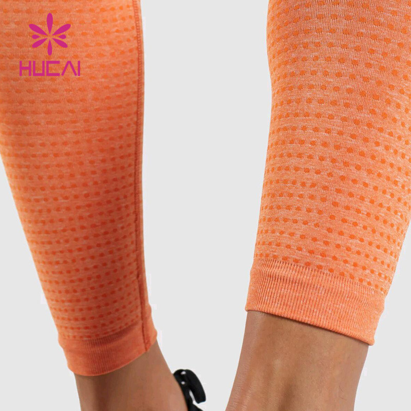 Side profile of orange seamless women's leggings showing mapped knit zones along the thigh and calf