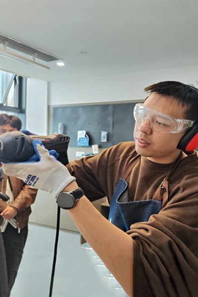 Worker testing a tool in a workshop during a product approval step