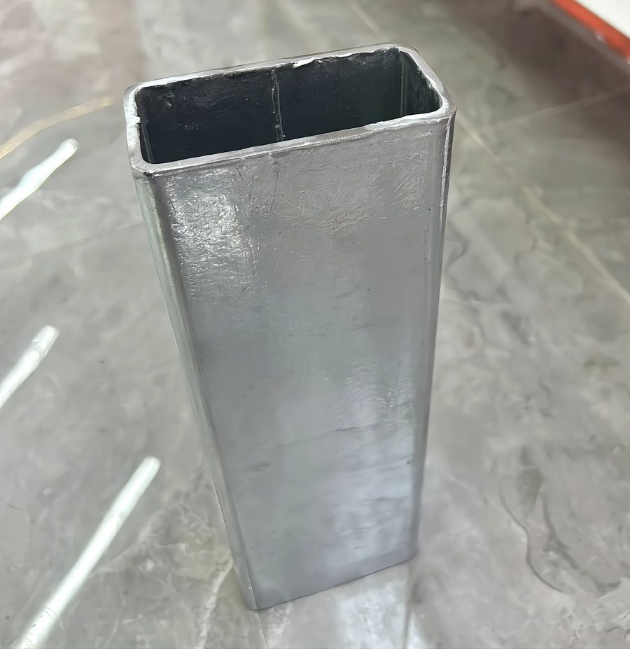 hot-dip galvanized rectangular tube sample showing spangled zinc coating and internal weld seam
