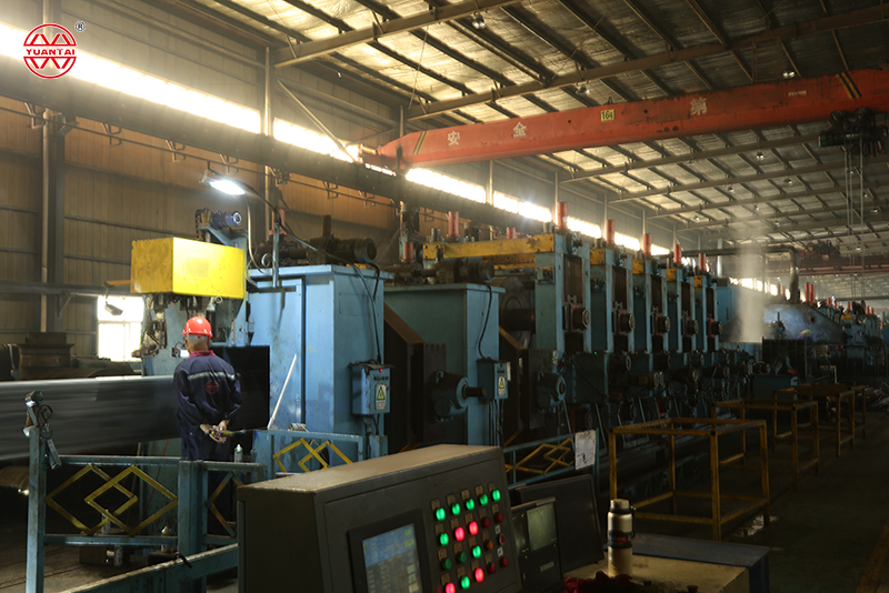 Advanced steel pipe cold forming mill and production line with automated control panel.