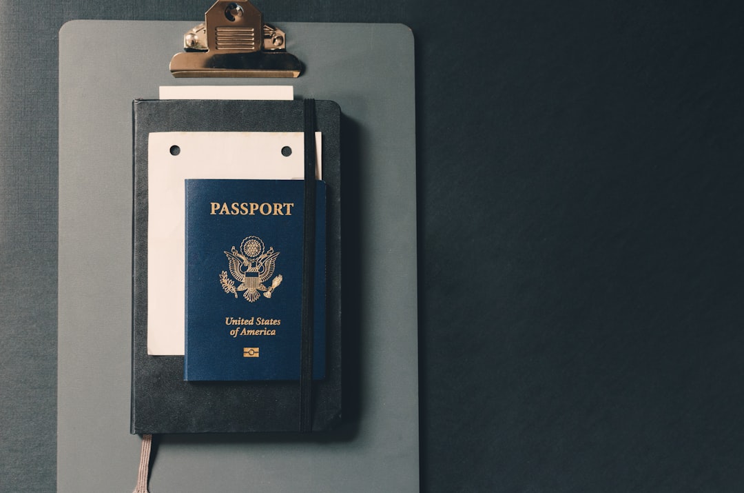 A small 30ml perfume bottle next to a passport and travel accessories.
