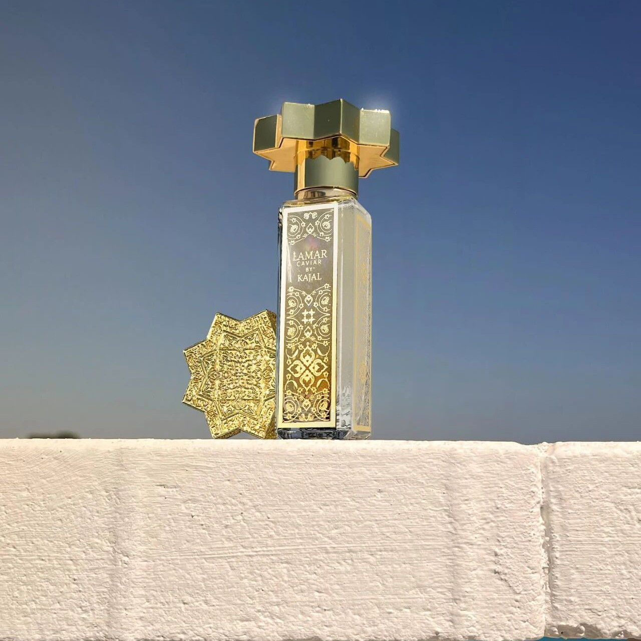 Elegant golden Kajal fragrance bottle with intricate detailing