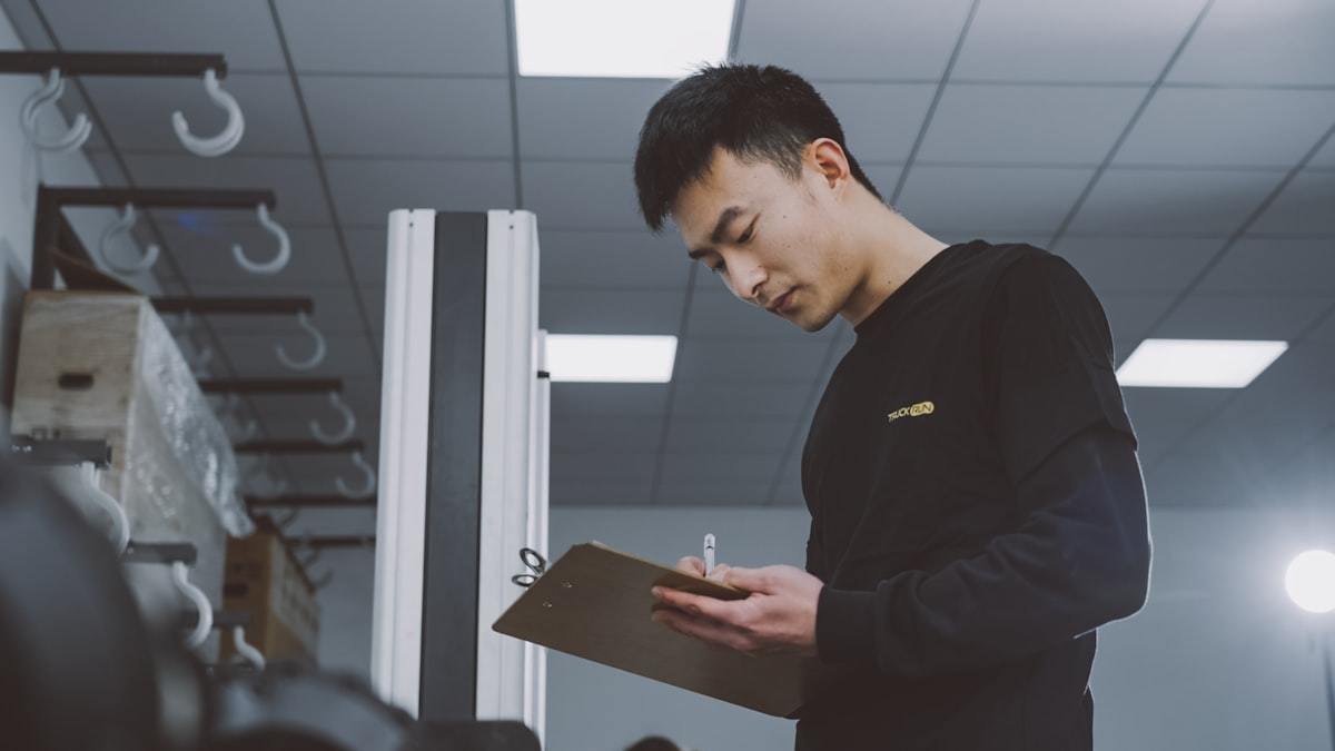 Quality inspector recording perfume box inspection results on a clipboard
