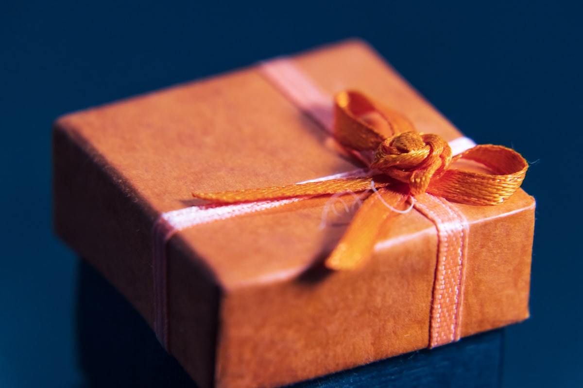 Orange wrapped perfume gift box with ribbon prepared for a seasonal set