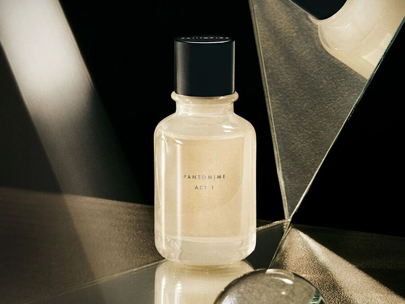 Minimalist round perfume bottle from PANTOMIME Parfum, featuring a matte black cap and transparent glass body.