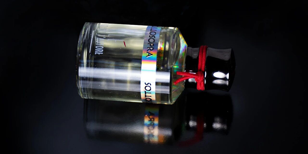 Elegant round Calé Fragranze d'Autore perfume bottle with black cap and artistic glass design.