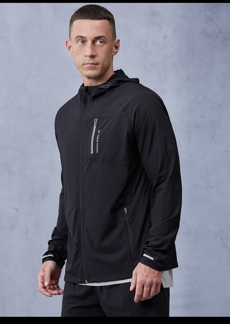 Male model wearing a black hooded full-zip men's running jacket in a lightweight woven shell with reflective trim, shown as the wind protection outer layer in a running jacket range