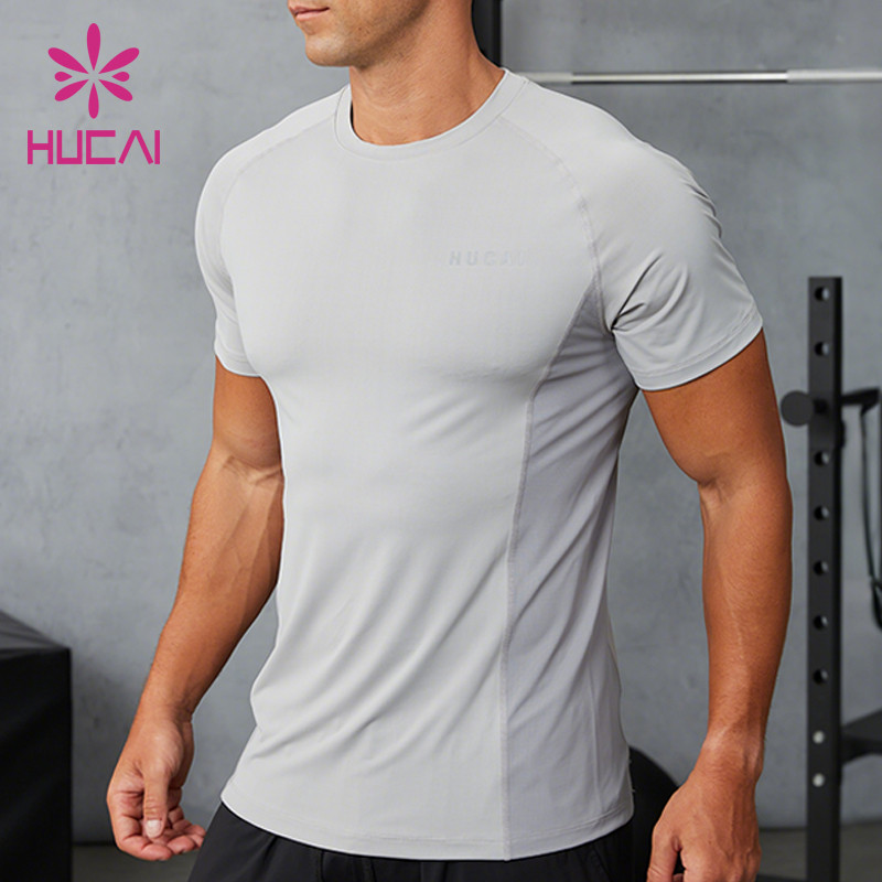 Men's light grey performance training T-shirt on model, raglan shoulder seam running from collar to underarm and a shaped side panel through the torso, with a clean finished hem
