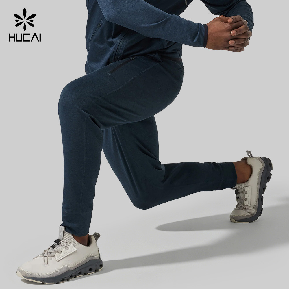 Model in motion wearing navy spacer knit joggers, showing tapered leg drape, ribbed cuffs and shape retention through the knee and hip