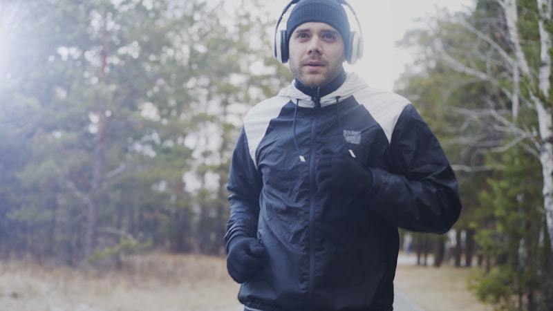 Man running outdoors in cooler weather wearing a lightweight activewear jacket