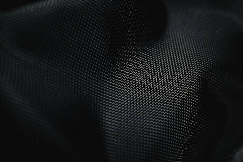 Close-up of a dark performance knit surface, where fabric structure and finish determine how a claim performs