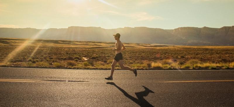 Man running in black shorts on a hot day, showing the sweat and moisture conditions functional activewear claims must address
