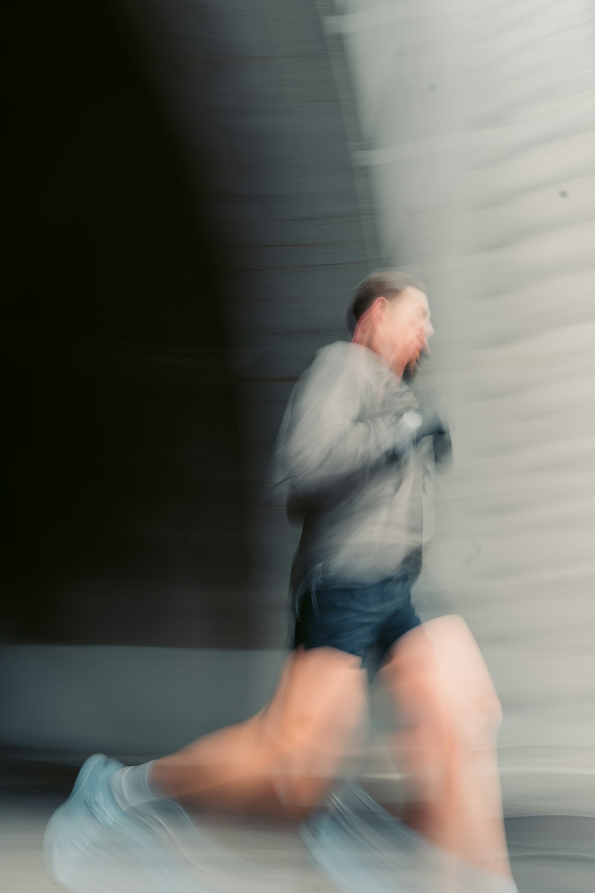 Runner in a light jacket and shorts, showing the layering and weather adaptability that trail programs need