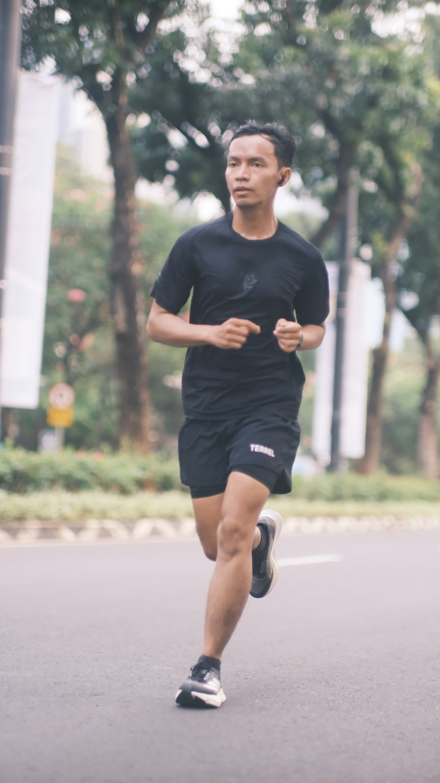 Male runner training on an open road in a long sleeve performance running top at golden hour