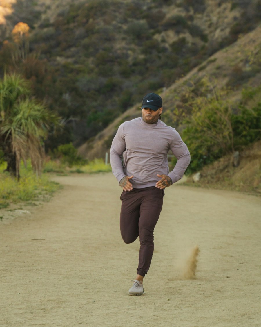 Male runner in a long sleeve running top on a trail, showing sleeve position at the forward swing