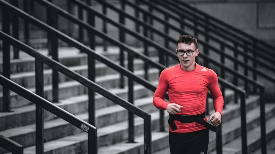 Male runner in a long sleeve compression top running up outdoor steps, showing forearm and cuff position