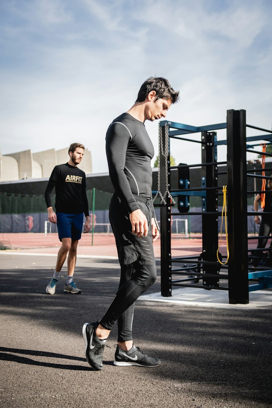 Male athlete in a fitted long sleeve training top outdoors, showing seam lines on the sleeve and shoulder
