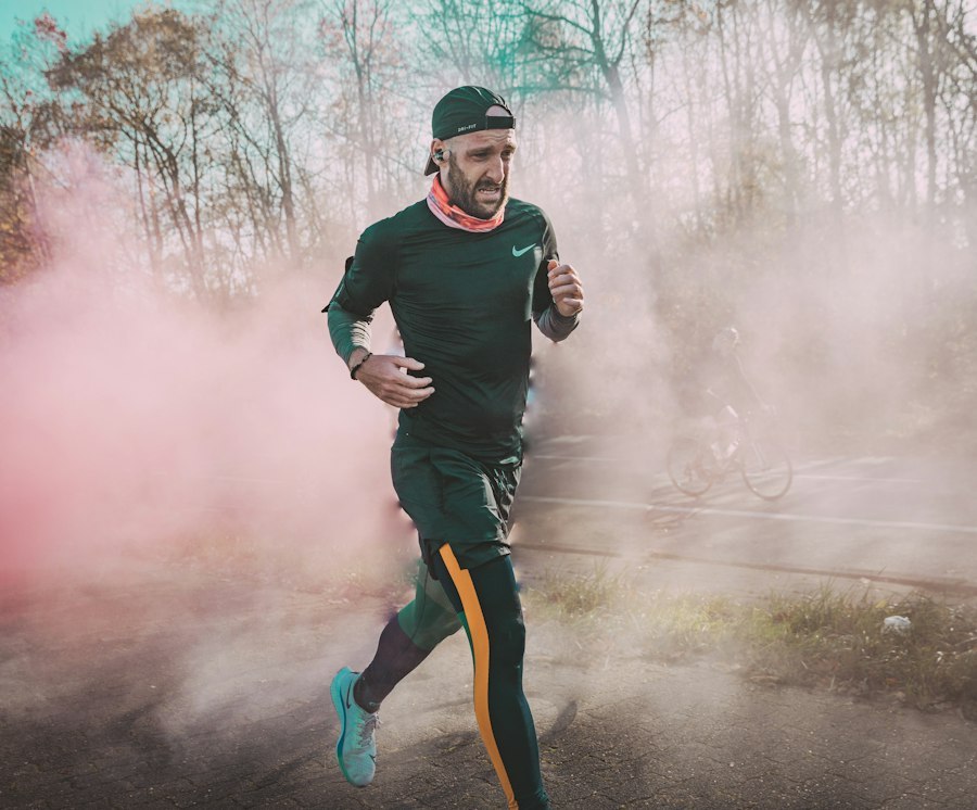 Male runner in a long sleeve top and tights running on an autumn forest road in cool weather