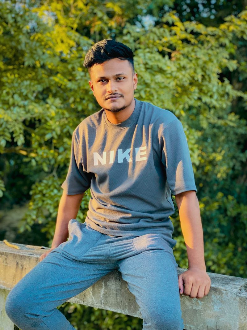 young man in sportswear sitting on a ledge