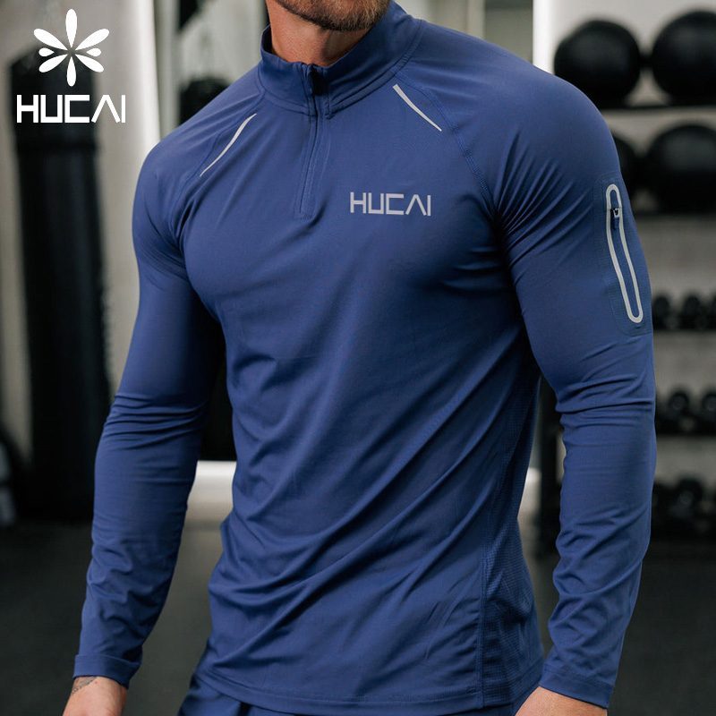 Men's navy compression fit long sleeve base layer top worn next to skin during an indoor gym training session