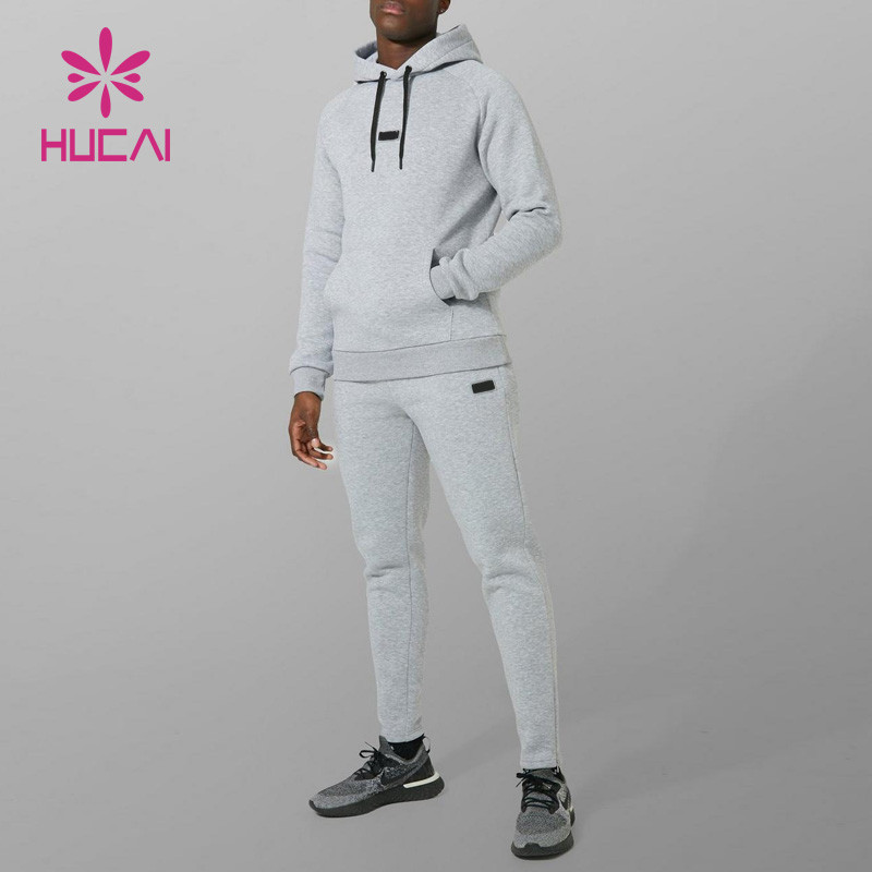 Men's light grey spacer knit hoodie and jogger set shown on a model, with raglan shoulder seams, kangaroo pocket, drawcord and ribbed cuffs