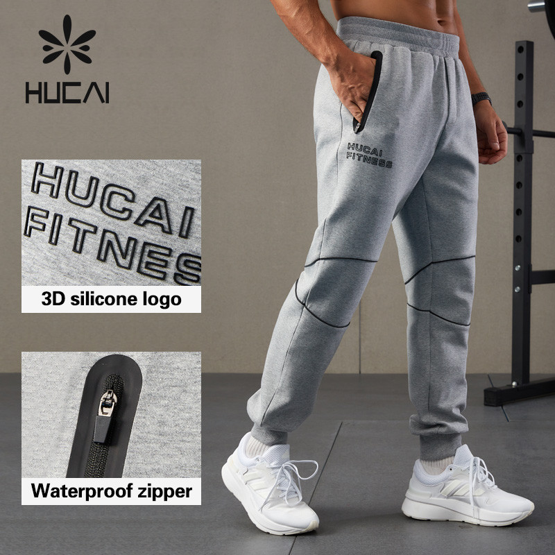 Men's grey spacer knit jogger detail showing a waterproof side zip pocket, elastic waistband with drawcord and 3D silicone logo placement