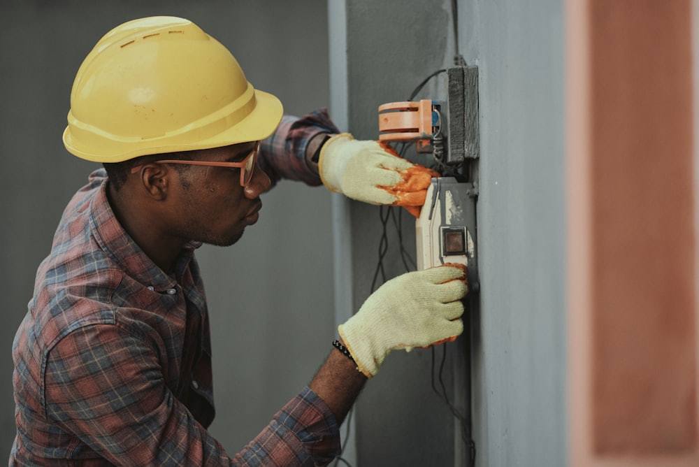 Licensed electrician wiring an industrial electrical connection during equipment commissioning
