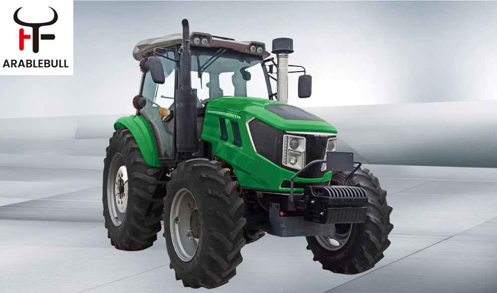 A small farm tractor with a front-end loader in a field at sunrise.