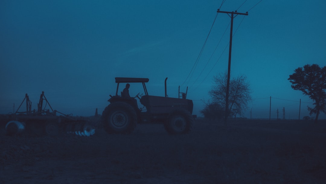 A modern tractor in a field at sunset