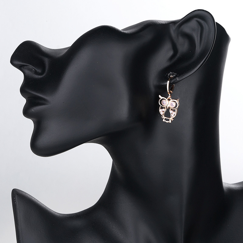 wearing white owl dangle huggie earring