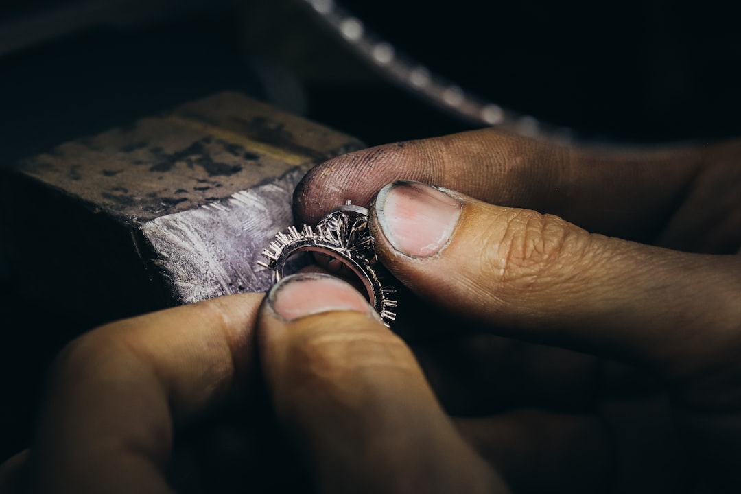 A person polishing a silver chain with a cloth