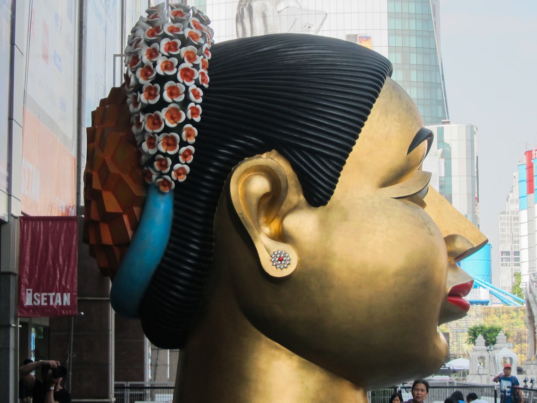 Side-by-side comparison of a woman wearing huggie earrings and large hoop earrings