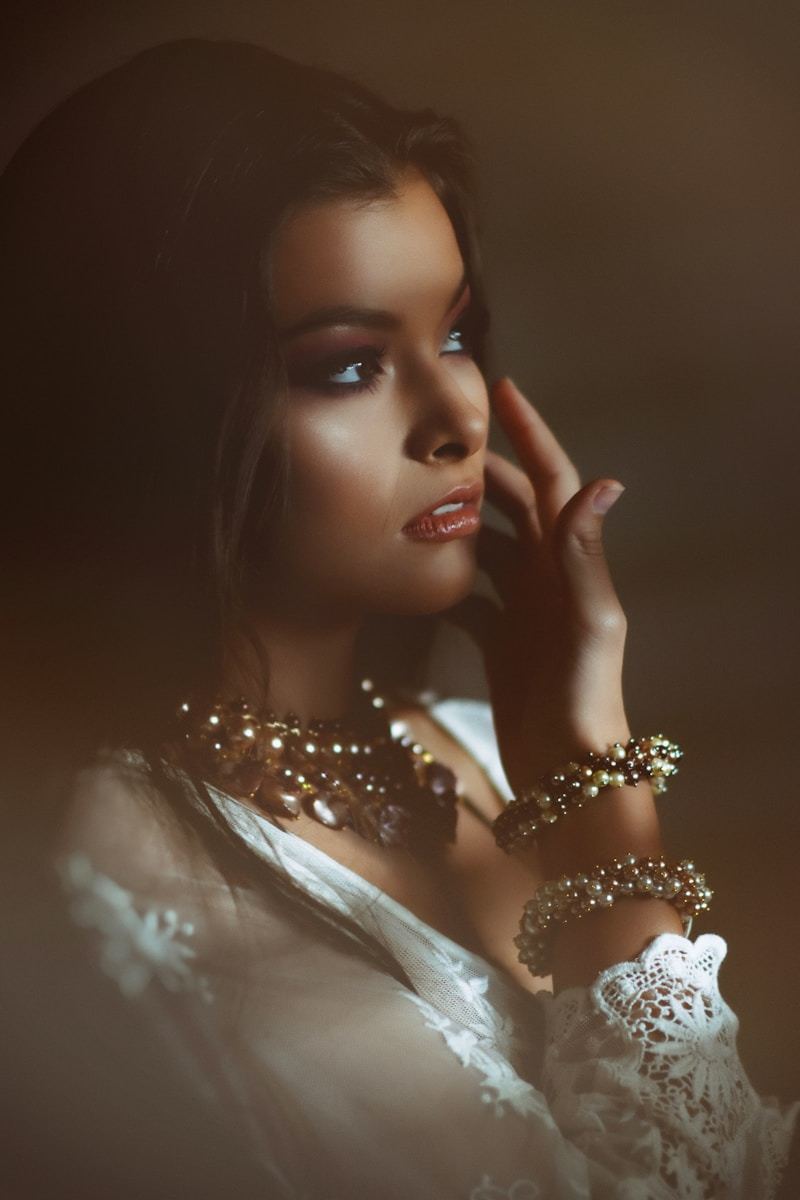Woman in white dress wearing elegant gold necklace