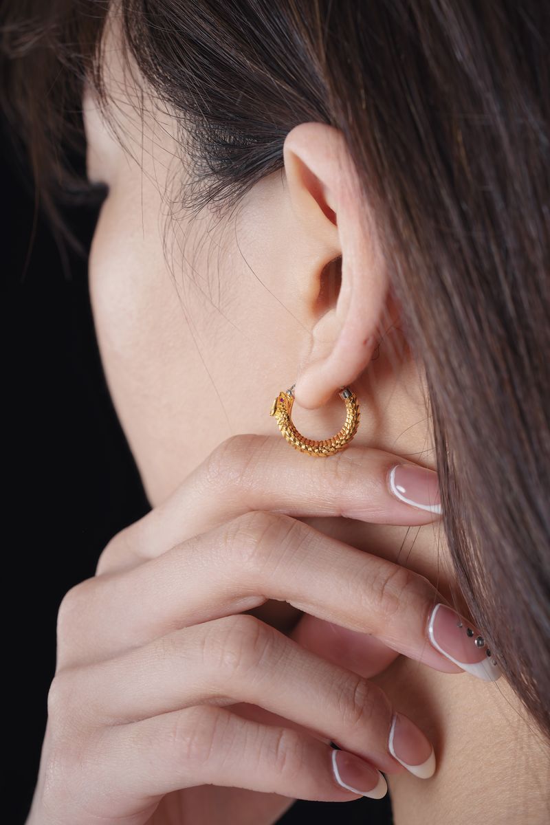 Trendy gold plated earrings being styled
