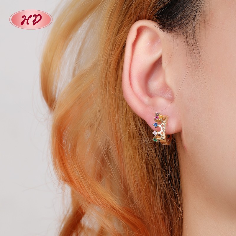 18K gold plated multicolor CZ crown huggie earrings worn on ear - HD Jewelry