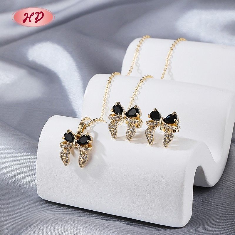 Détail du collier et des boucles d'oreilles nœud papillon zircone noire