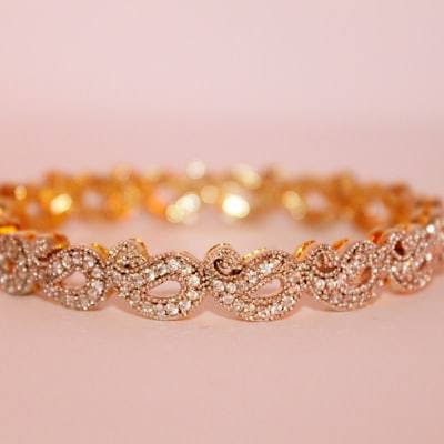 Gold plated hoop earrings on a neutral surface